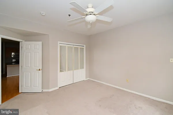an empty room with a ceiling fan and a window