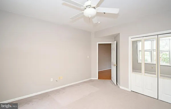 an empty room with a ceiling fan and a window