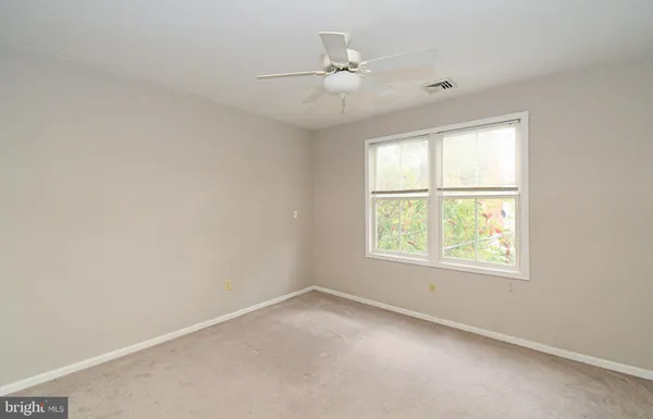 an empty room with a window and a fan