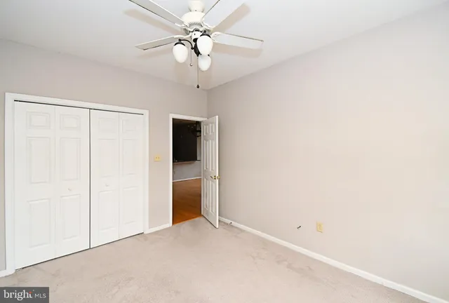 an empty room with a ceiling fan and a window