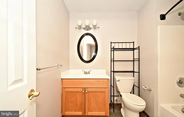 a bathroom with a granite countertop toilet sink and mirror