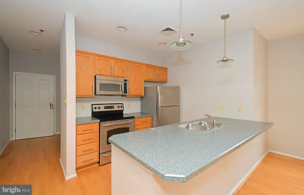 a kitchen with stainless steel appliances granite countertop a sink a stove and a refrigerator