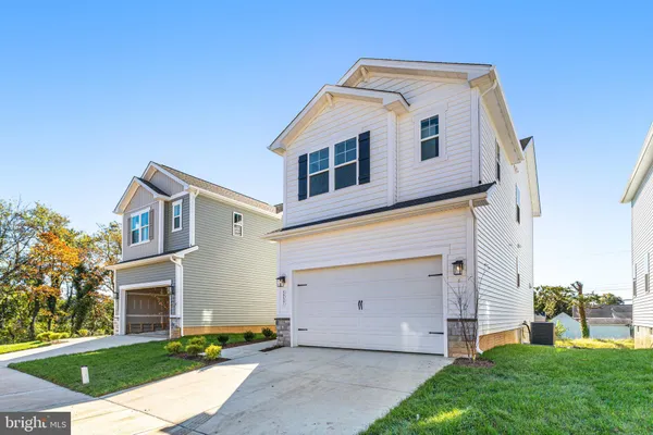 a front view of a house with a garden and garage