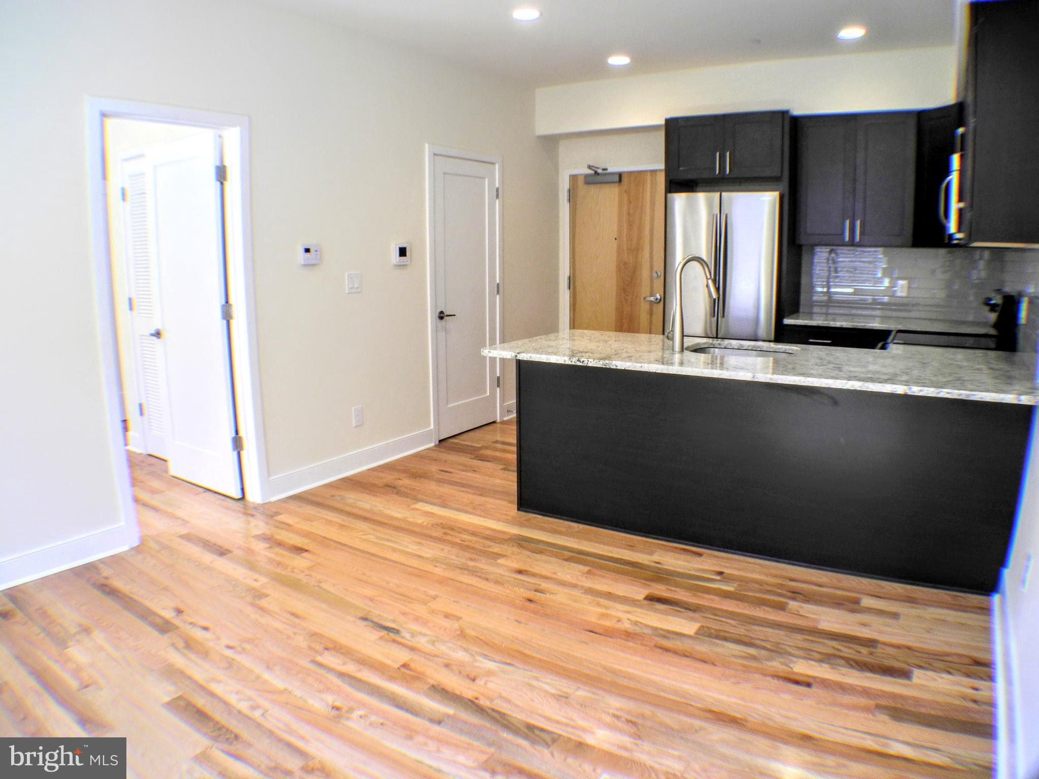 a view of kitchen with stainless steel appliances wooden cabinets and entryway