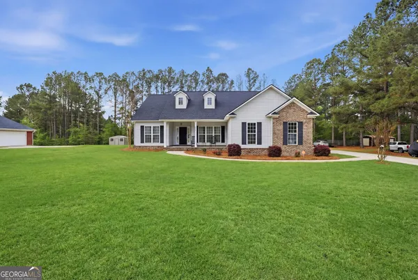 a front view of a house with a yard and trees