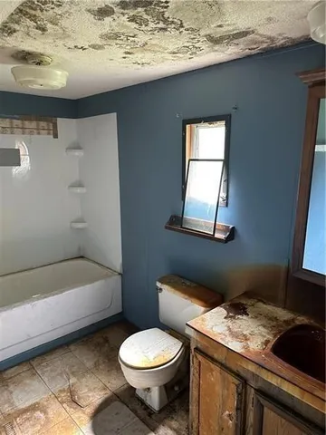 a bathroom with a granite countertop toilet sink and mirror