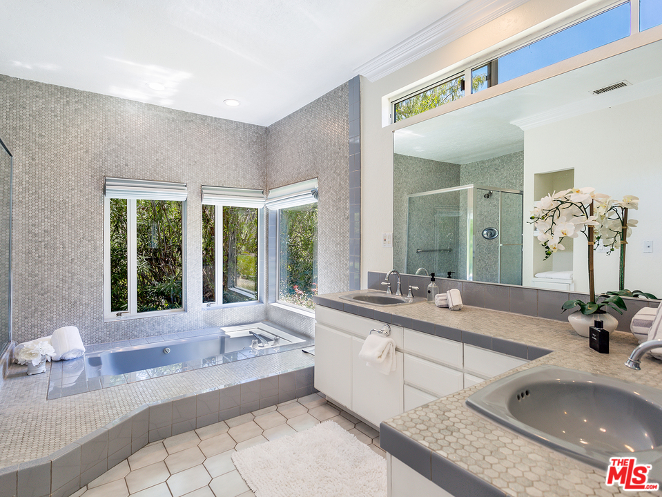 2069 Cold Canyon Road Calabasas, CA 91302 - Photo 22 of 34 a large bathroom with a granite countertop tub a sink and a large window