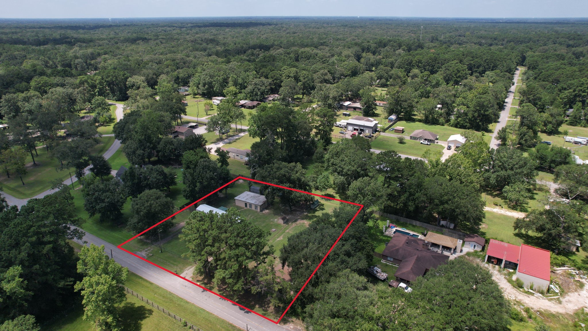30 East Old Field Road Huffman, TX 77336 - Photo 27 of 31 An aerial perspective showcases the full acre, highlighting the unrestricted property boundaries and mature tree canopy. All depicted property lines, boundaries, and site overlays are visual approximations and should not be used as a legal survey or for precise engineering measurements.