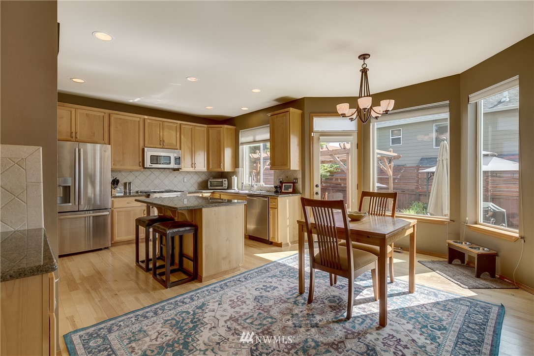 21105 1st Avenue West Bothell, WA 98021 - Photo 16 of 40 a kitchen with stainless steel appliances granite countertop a stove top oven a sink refrigerator and cabinets