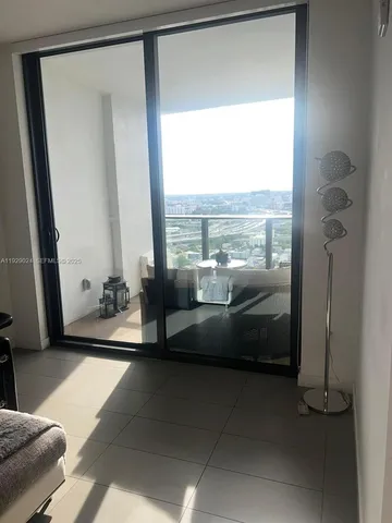 a living room with furniture and a floor to ceiling window