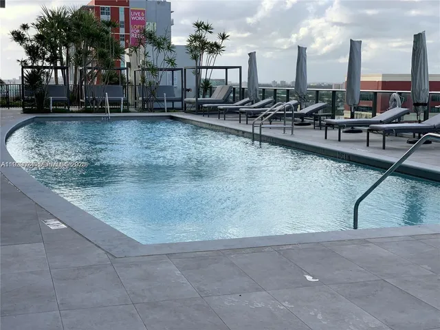 a living room with patio furniture and a large window