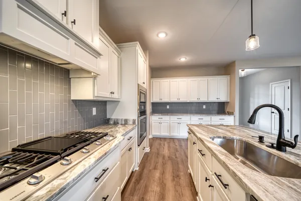 a kitchen with kitchen island granite countertop a sink stainless steel appliances and cabinets