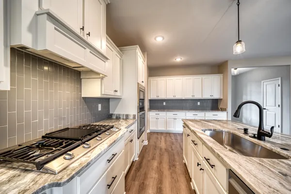 a kitchen with kitchen island granite countertop a sink stainless steel appliances and cabinets