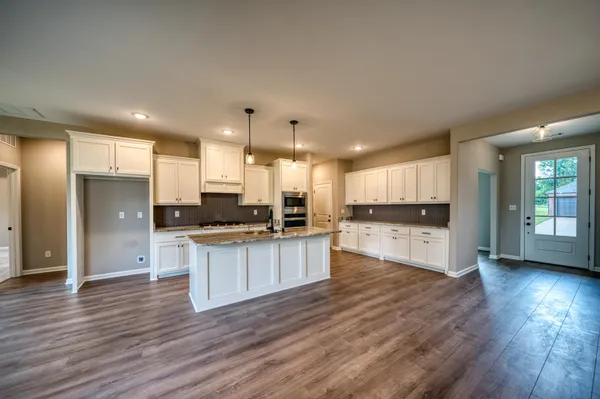 a view of a kitchen with granite countertop cabinets