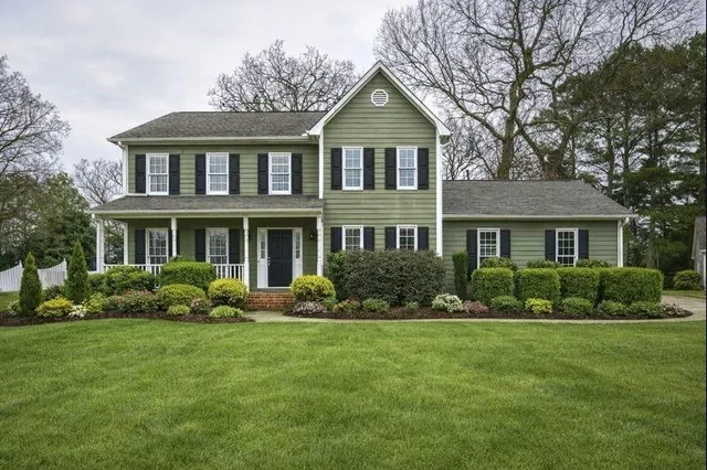a front view of a house with a yard and trees