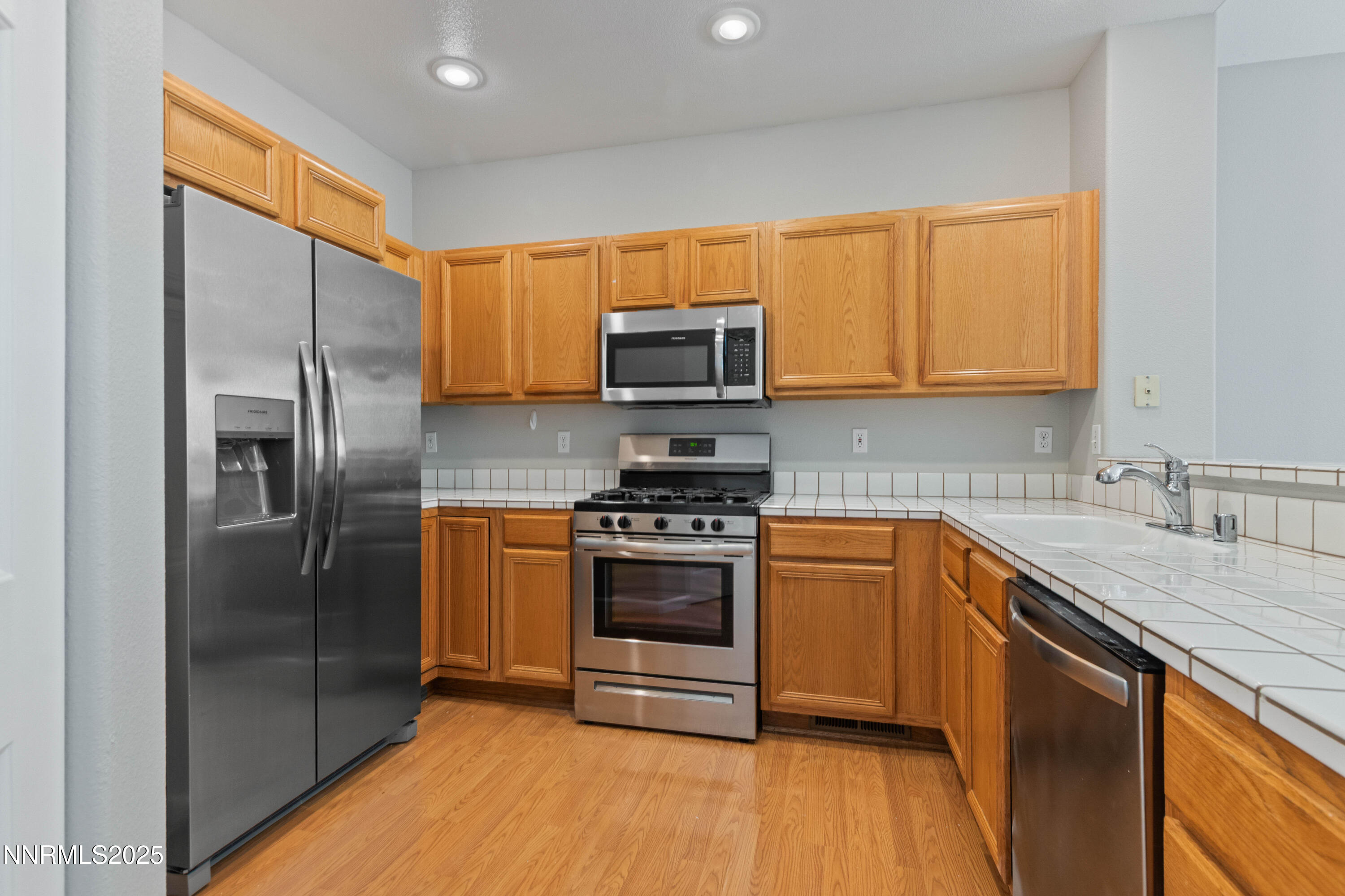 860 Caughlin Crossing Reno, NV 89519 - Photo 8 of 21 a kitchen with stainless steel appliances granite countertop a stove a refrigerator and a sink