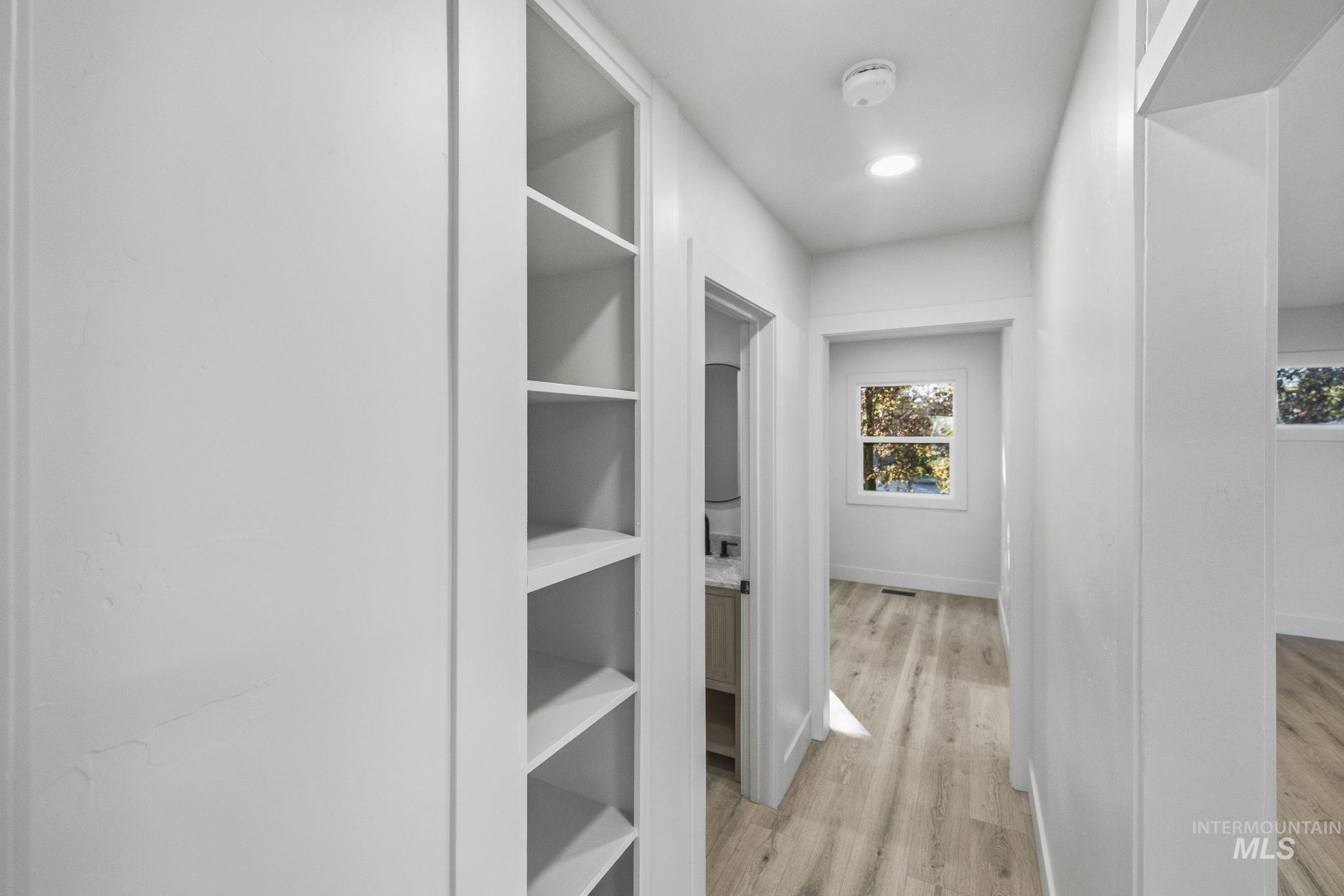 3113 West Overland Road Boise, ID 83705 - Photo 26 of 40 Recessed built-in shelving, wood-finish flooring, white trim, and recessed lighting