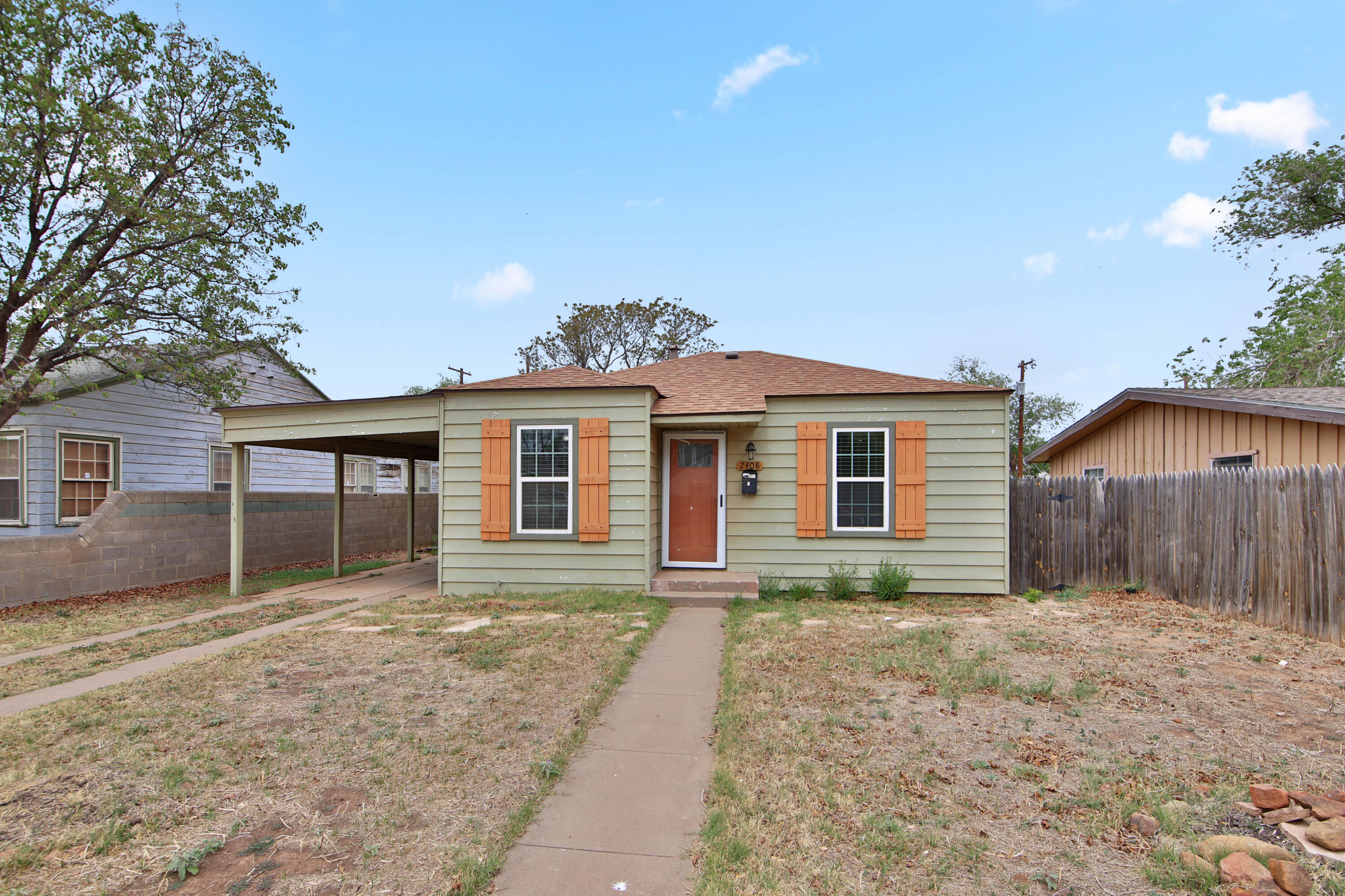 a front view of house with yard and trees around
