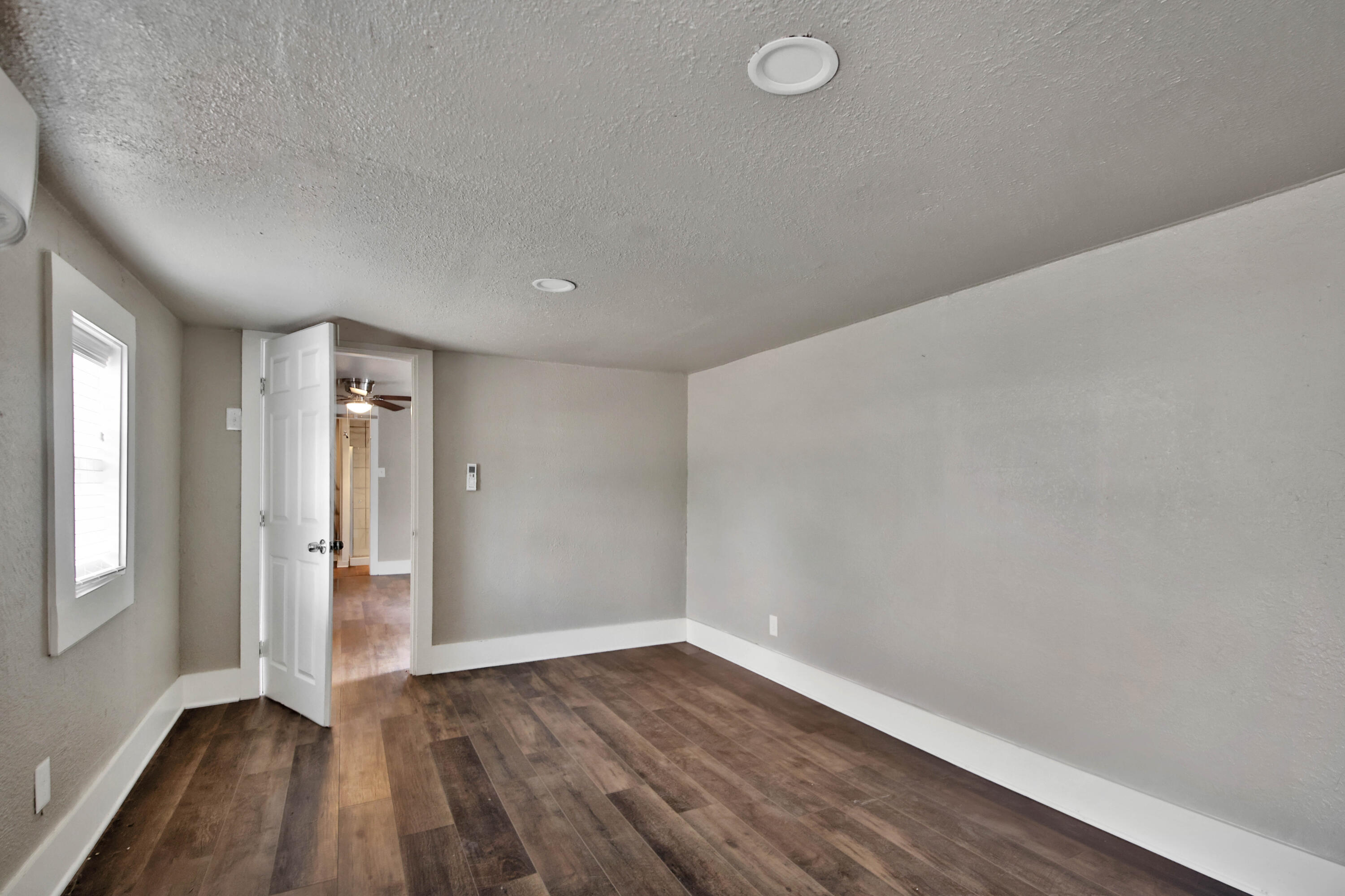 2408 24th Street Lubbock, TX 79411 - Photo 18 of 32 an empty room with wooden floor and windows