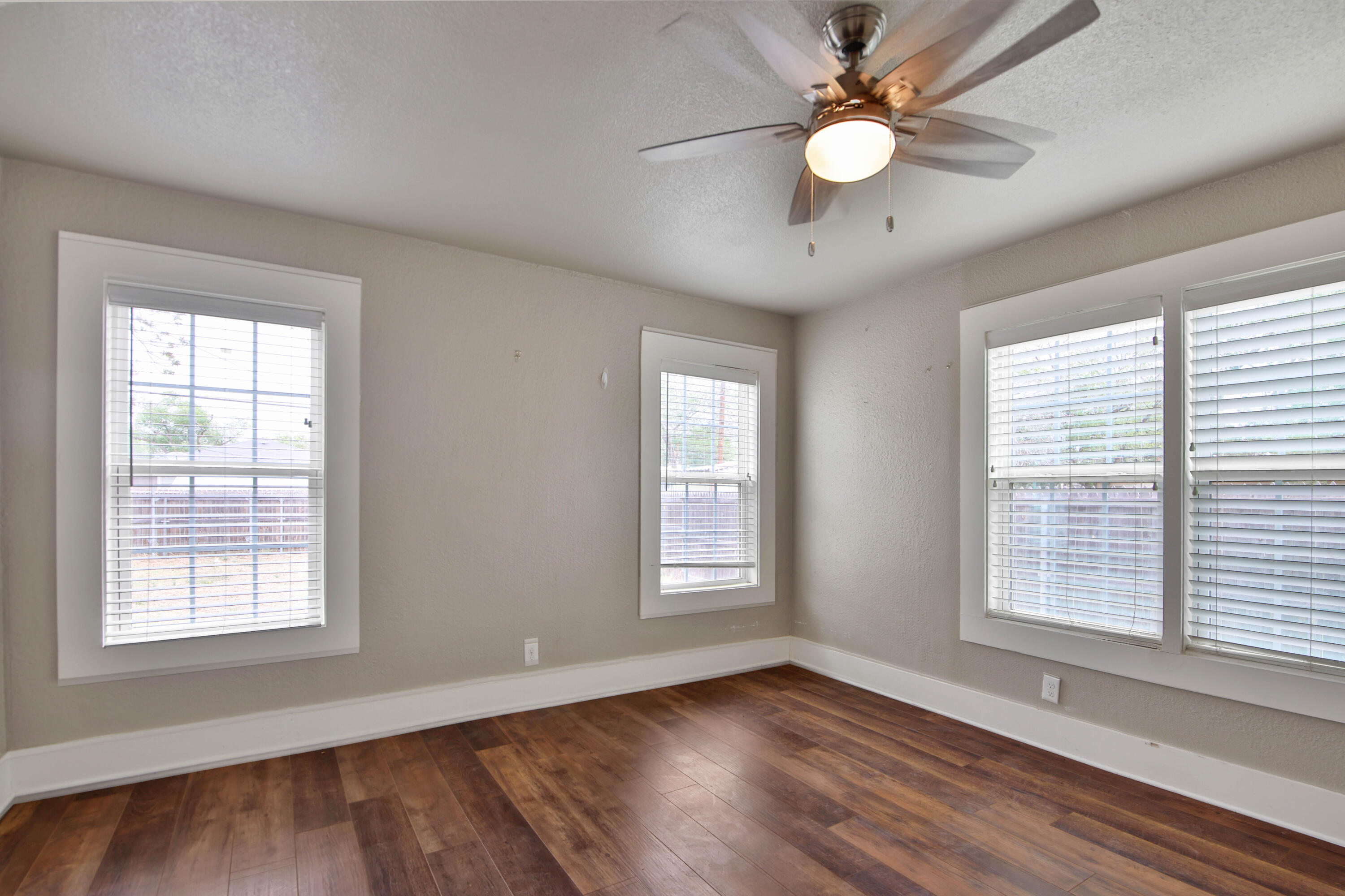 2408 24th Street Lubbock, TX 79411 - Photo 21 of 32 a view of an empty room with wooden floor and a window