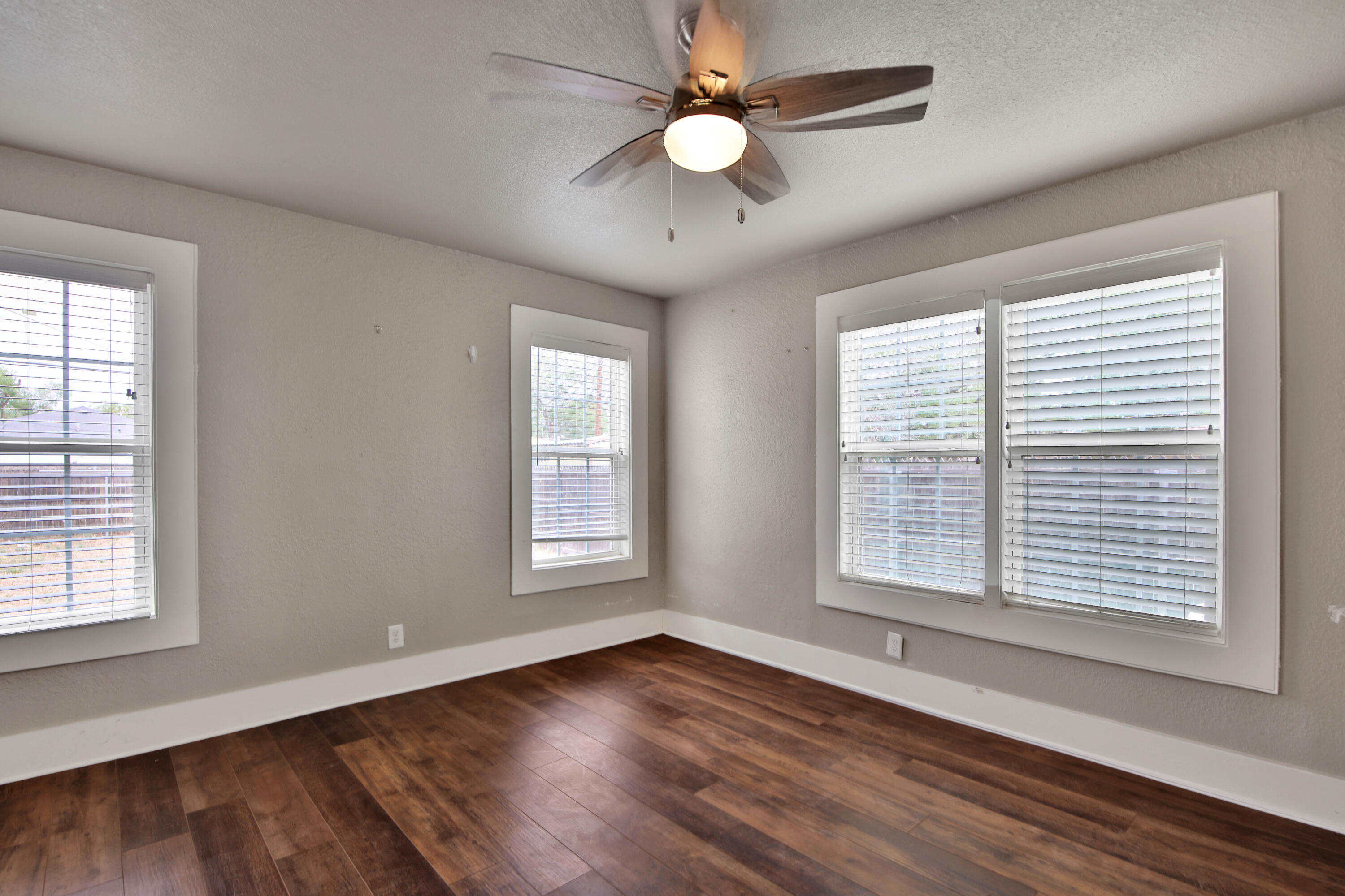 2408 24th Street Lubbock, TX 79411 - Photo 22 of 32 a view of an empty room with wooden floor and a window
