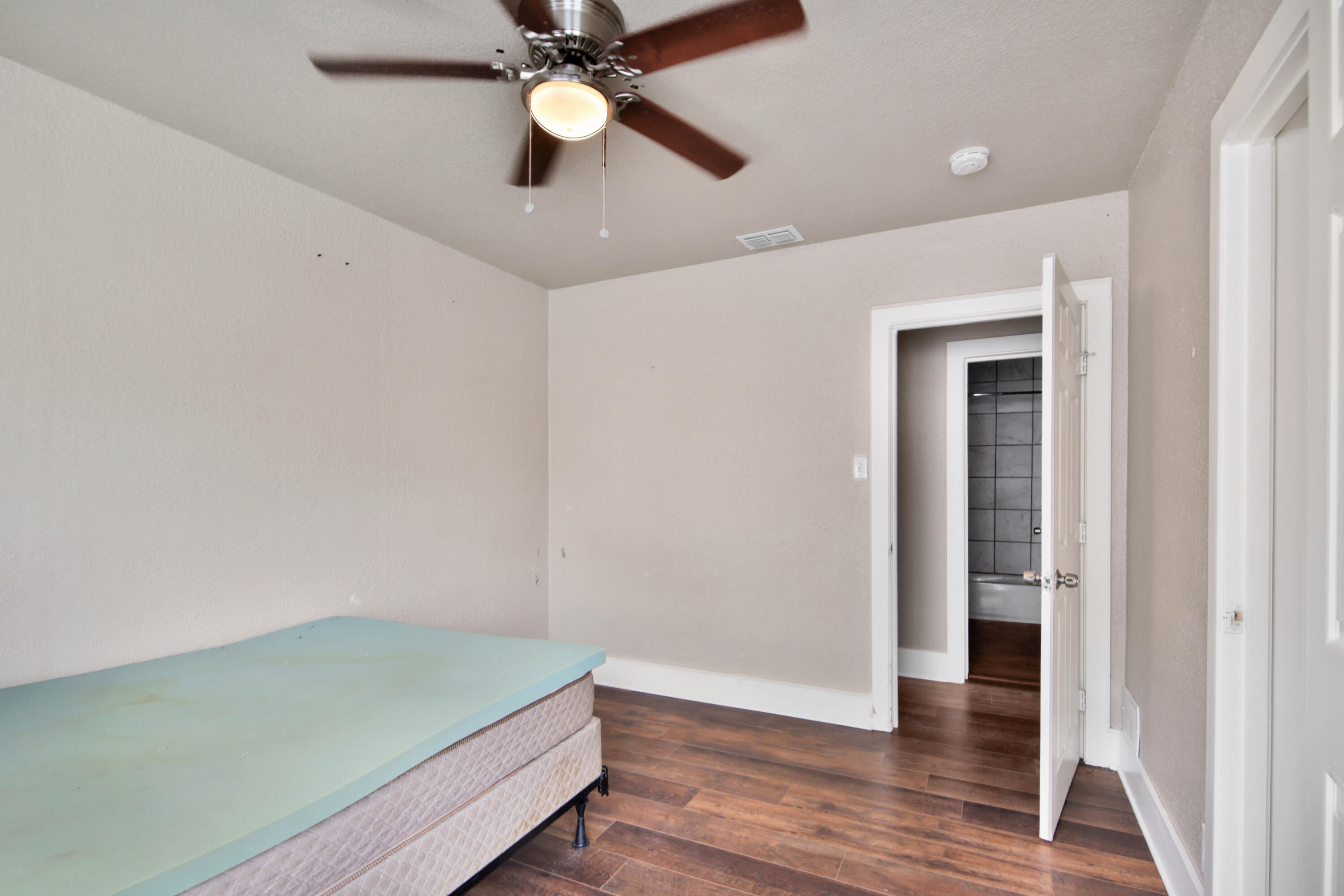 2408 24th Street Lubbock, TX 79411 - Photo 25 of 32 an empty room with wooden floor and ceiling fan