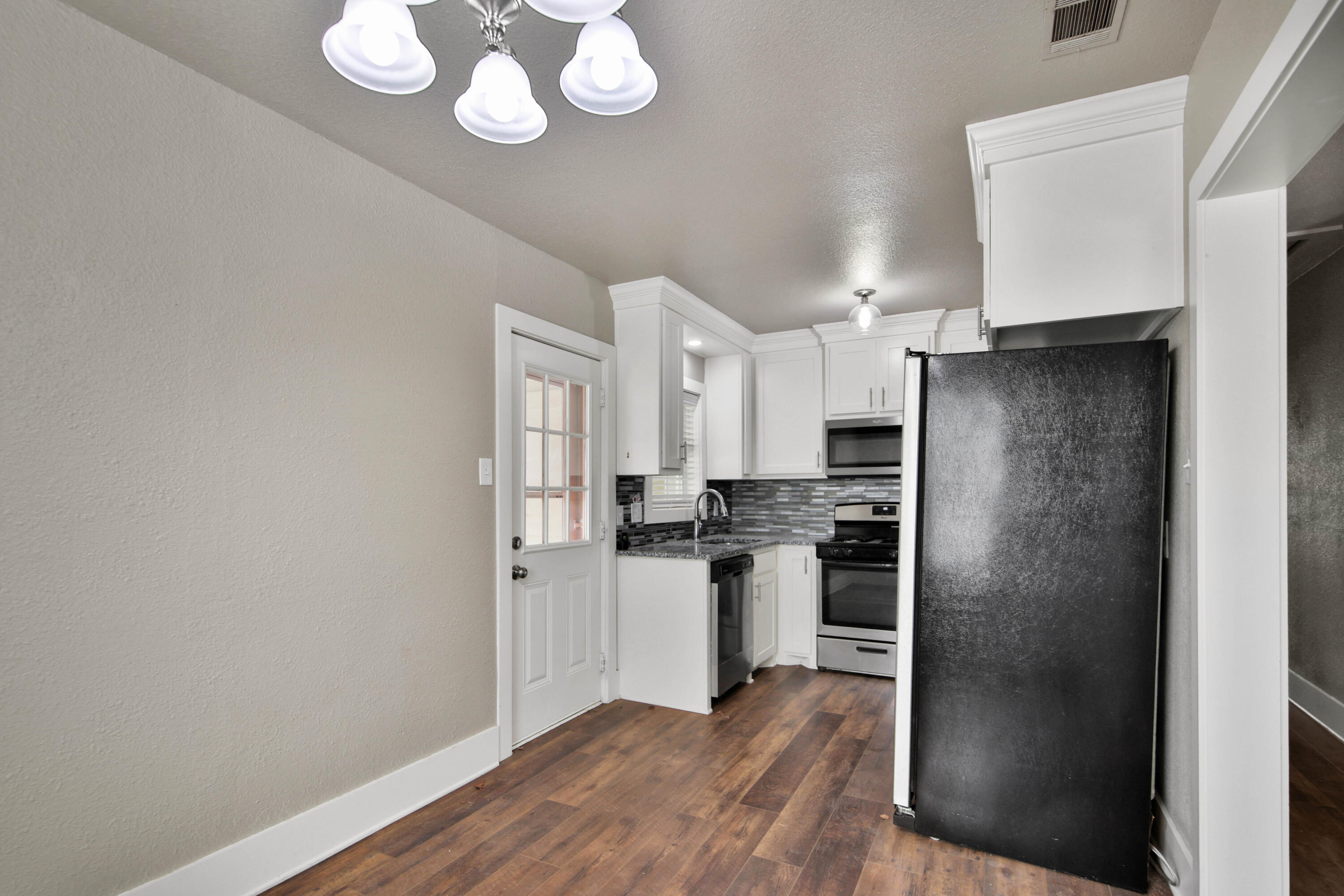 2408 24th Street Lubbock, TX 79411 - Photo 6 of 32 a kitchen with stainless steel appliances granite countertop a refrigerator and a stove top oven