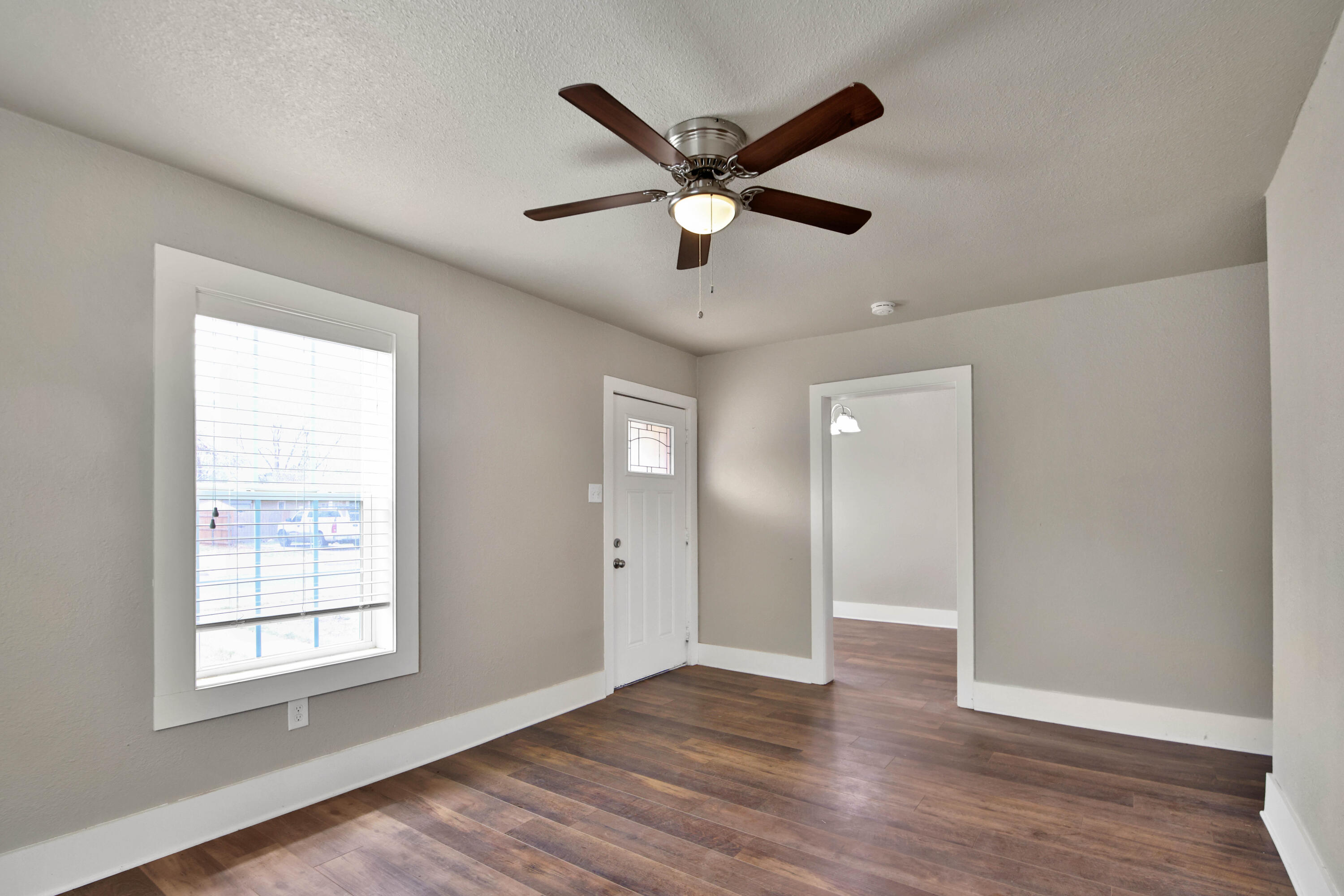 2408 24th Street Lubbock, TX 79411 - Photo 9 of 32 a view of an empty room with wooden floor and a window