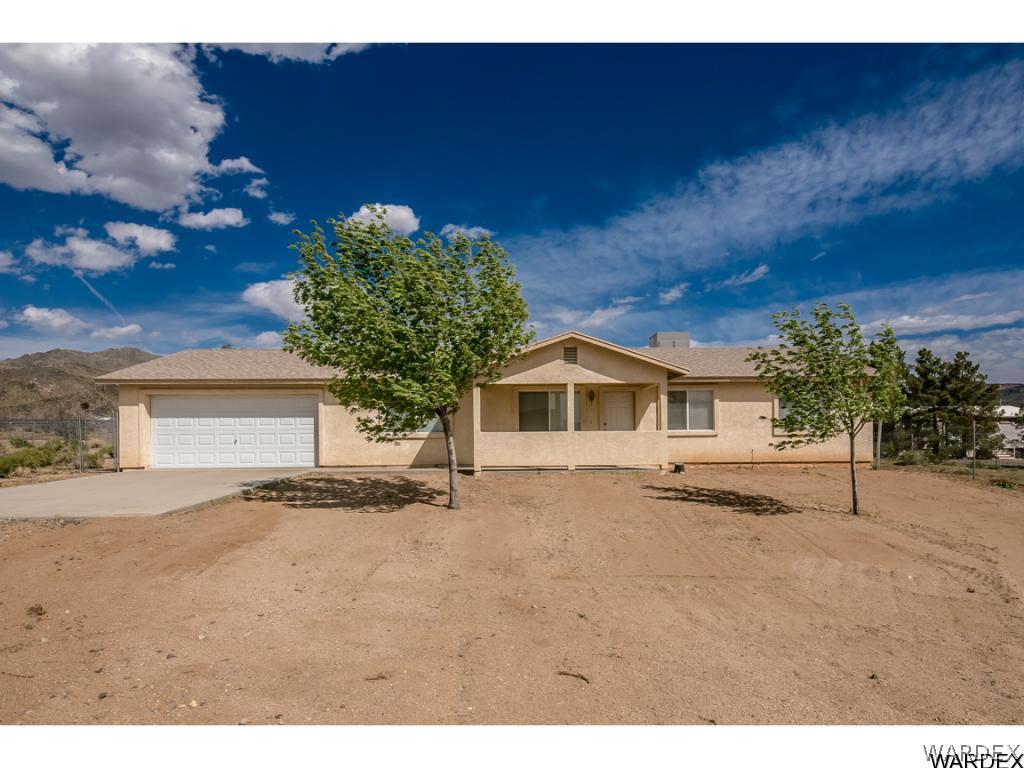 3620 Bosque Road Golden Valley, AZ 86413 - Photo 14 of 35 a front view of a house with a yard covered with trees