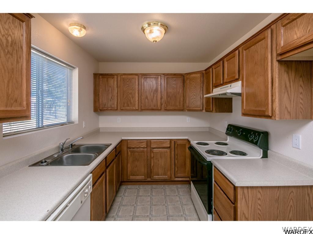 3620 Bosque Road Golden Valley, AZ 86413 - Photo 4 of 35 a kitchen with a sink a stove a microwave cabinets and a window