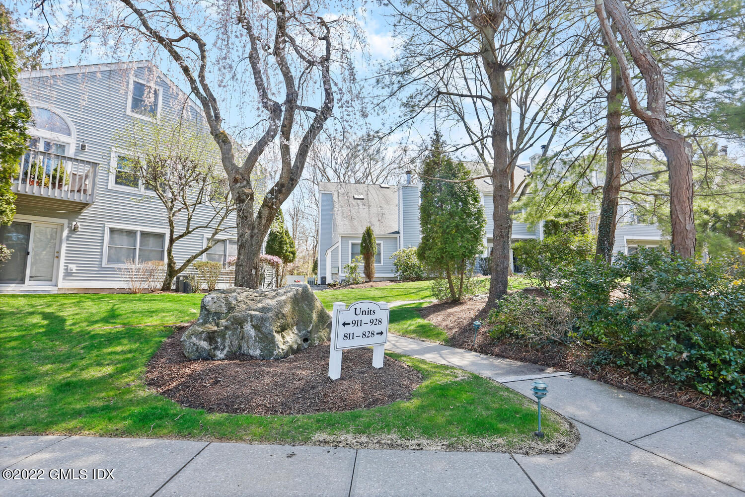 351 Pemberwick Road, Unit 815 Greenwich, CT 06831 - Photo 9 of 11 a front view of a house with garden and trees