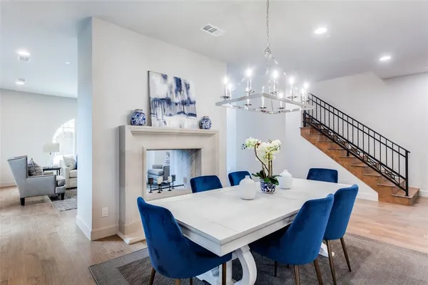 a view of a dining room with furniture a chandelier and wooden floor