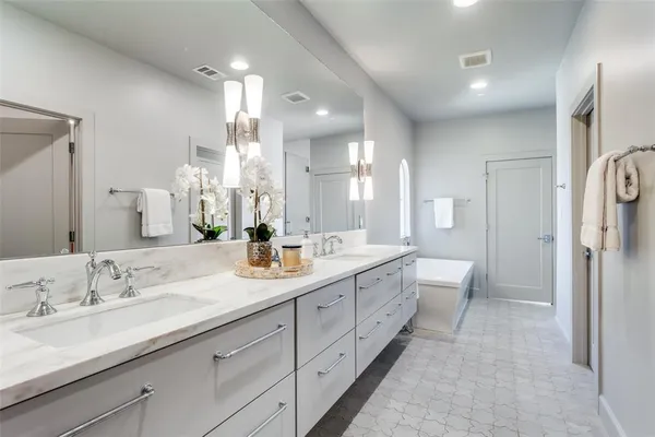 a spacious bathroom with a double vanity sink mirror double and shower
