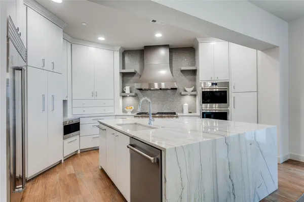 a kitchen with kitchen island granite countertop a sink stove and refrigerator
