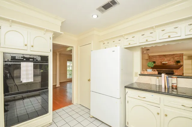a kitchen with granite countertop white cabinets and white appliances