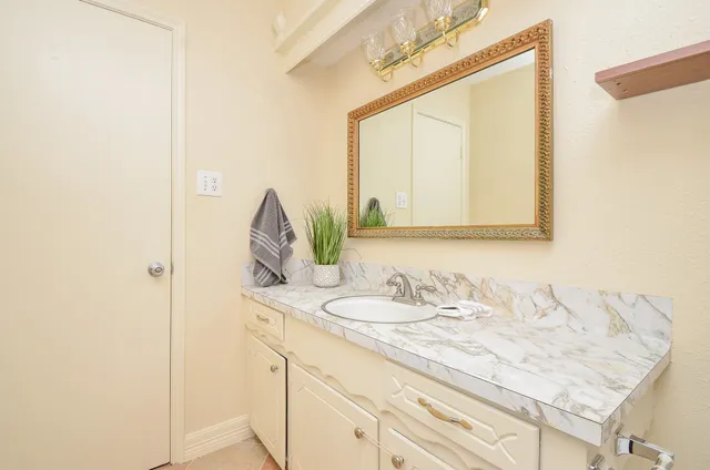 a bathroom with a granite countertop sink a toilet and shower