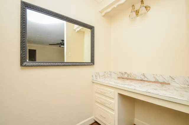 an empty room with wooden floor and ceiling fan