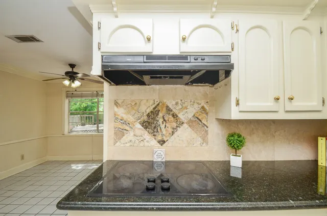 a kitchen with granite countertop white cabinets and sink