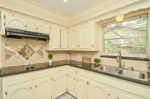 a kitchen with granite countertop a sink and cabinets