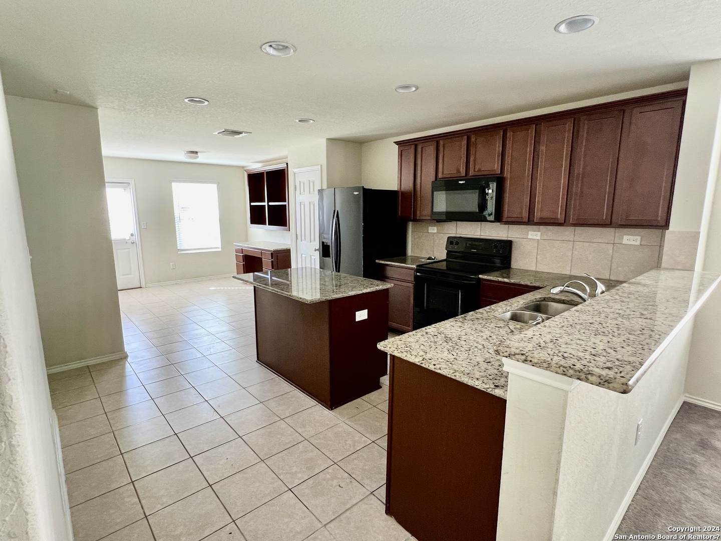 a kitchen with stainless steel appliances granite countertop a stove top oven a sink a counter top space and cabinets