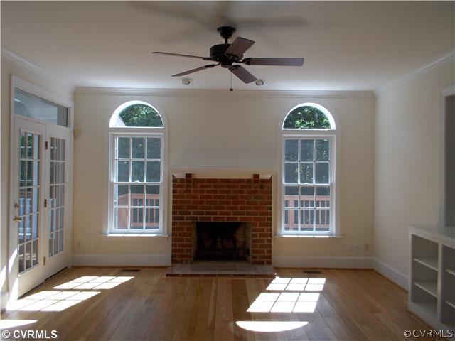 1920 Corner Rock Road Midlothian, VA 23113 - Photo 8 of 23 an empty room with windows a fireplace and wooden floor