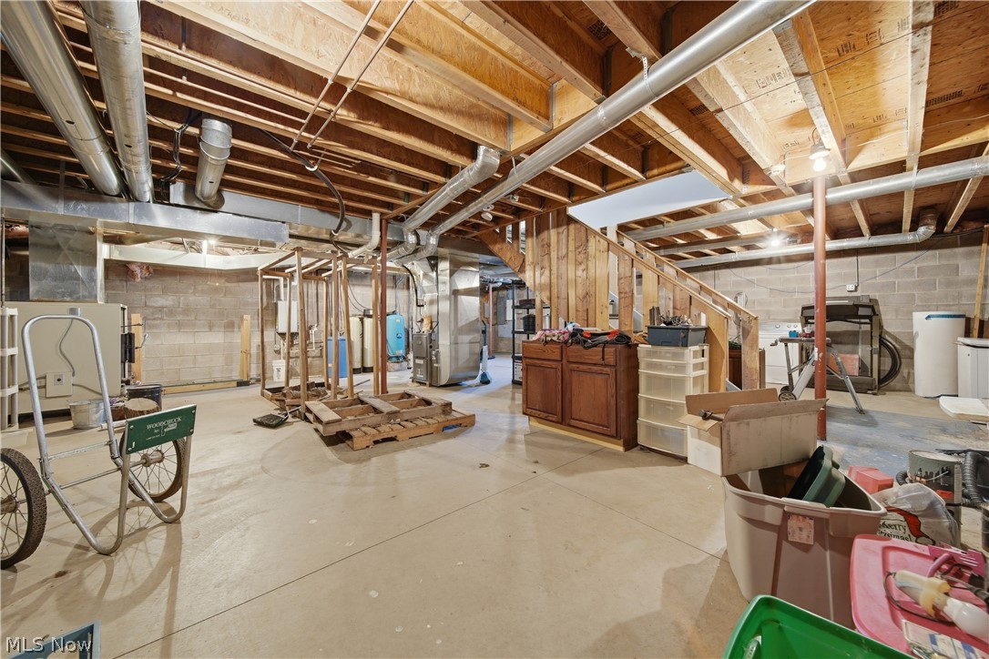 12159 Lawndell Road Southwest Beach City, OH 44608 - Photo 34 of 49 Unfinished basement featuring concrete flooring, exposed wood joists, block wall construction, and an exposed wood staircase