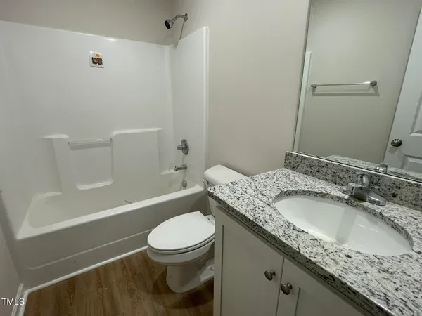 a bathroom with a granite countertop sink a toilet and shower
