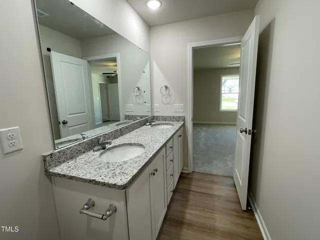 a bathroom with a granite countertop sink and a mirror