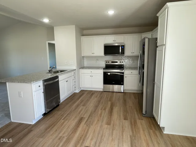 a kitchen with stainless steel appliances a stove a sink and a refrigerator