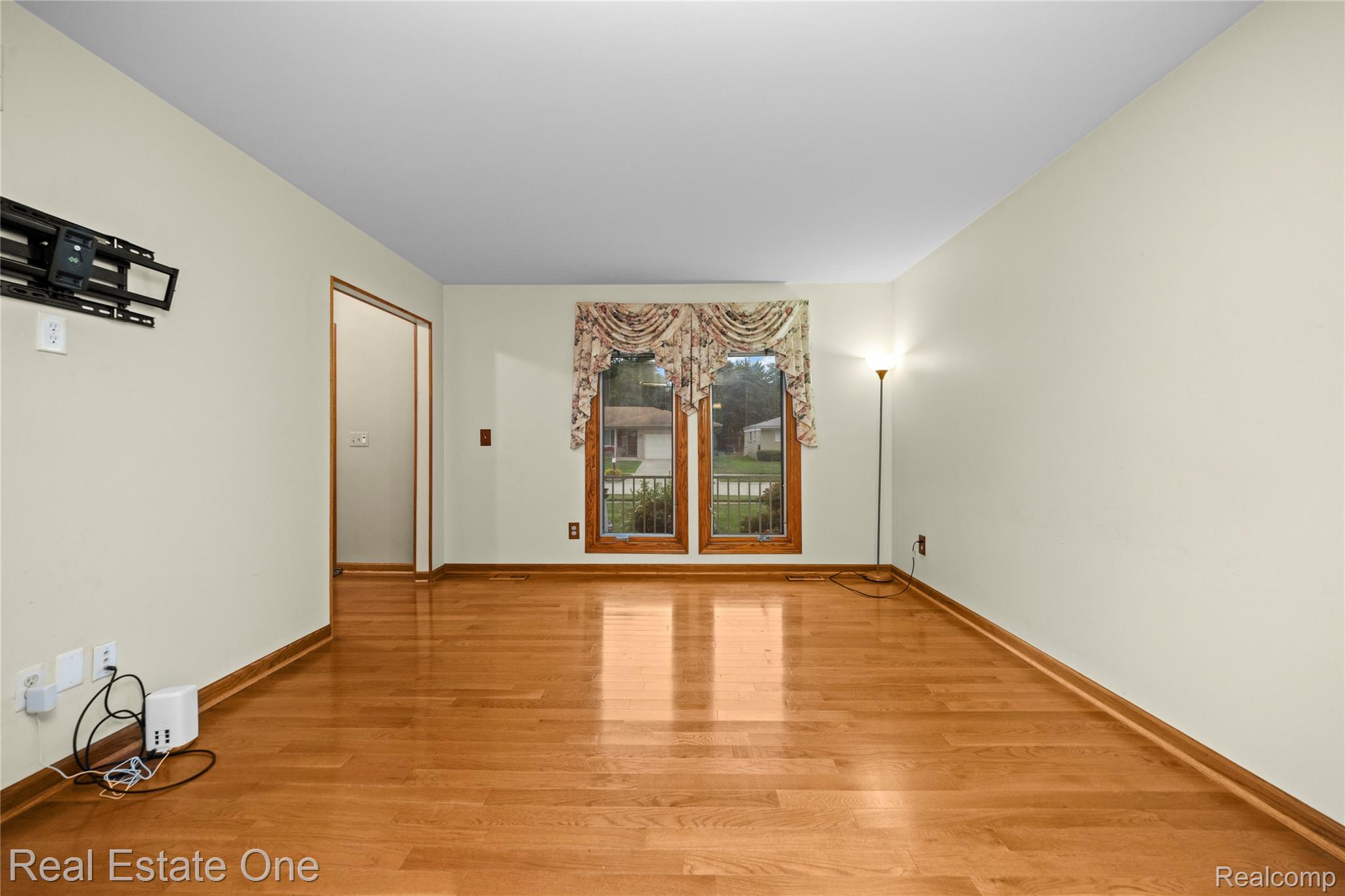 39750 Cheviot Road Canton, MI 48188 - Photo 11 of 71 Warm wood-finish flooring with light wall tones and natural light from a window with wood trim