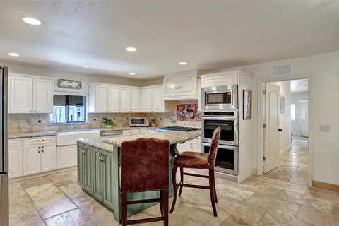 a bathroom with a granite countertop sink a toilet and a mirror