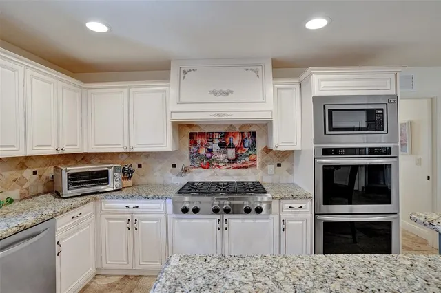 a bathroom with a granite countertop sink mirror vanity and toilet