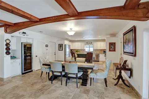 a kitchen with stainless steel appliances granite countertop a stove top oven a sink dishwasher and a refrigerator with wooden floor