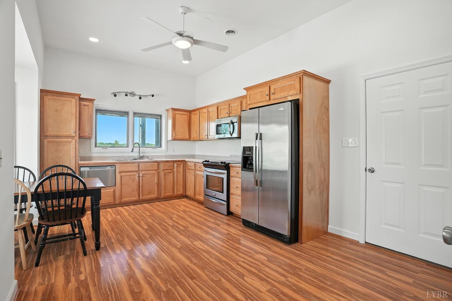 1433 Piney Mountain Road Appomattox, VA 24522 - Photo 18 of 68 a kitchen with stainless steel appliances granite countertop a refrigerator a stove a sink and a dining table with wooden floor